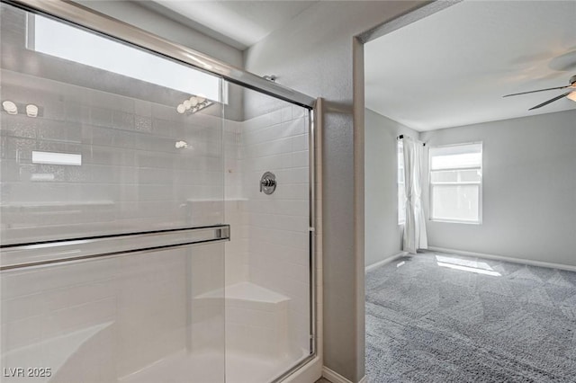 bathroom with a ceiling fan, a shower stall, and baseboards