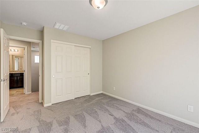 unfurnished bedroom featuring light colored carpet, baseboards, and a closet