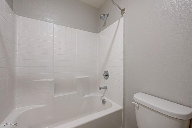 full bathroom with a textured wall, toilet, and  shower combination