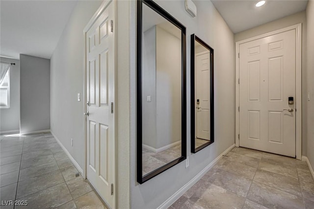 hall with baseboards and recessed lighting