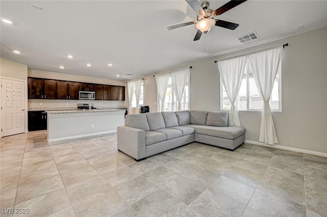 living room featuring baseboards, recessed lighting, and a ceiling fan