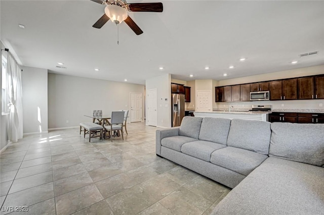 living area with baseboards, recessed lighting, and ceiling fan