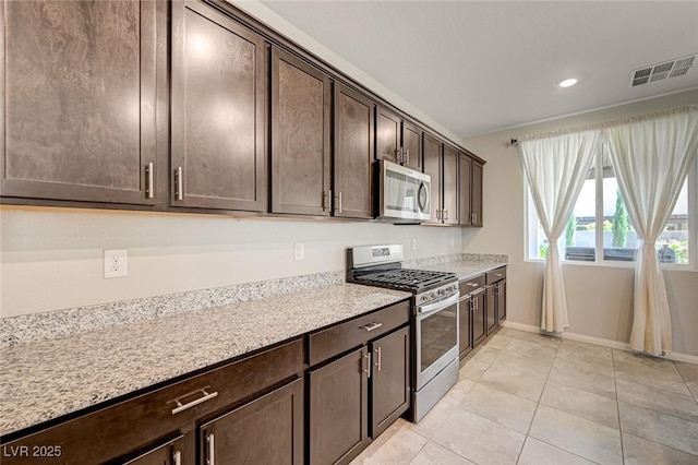 kitchen with appliances with stainless steel finishes, dark brown cabinetry, light tile patterned floors, baseboards, and recessed lighting