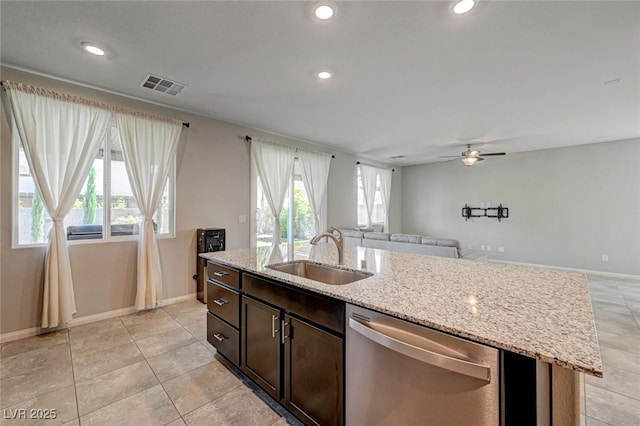 kitchen with a sink, dishwasher, open floor plan, ceiling fan, and baseboards