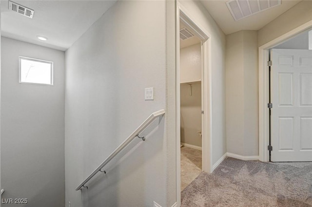 hall with an upstairs landing, carpet, and baseboards