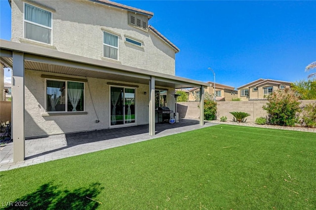back of house with stucco siding and a patio