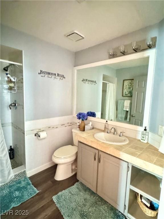 full bathroom with a shower stall, toilet, wood finished floors, and vanity