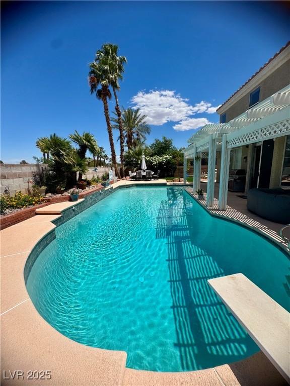swimming pool featuring a pergola, a diving board, and a patio