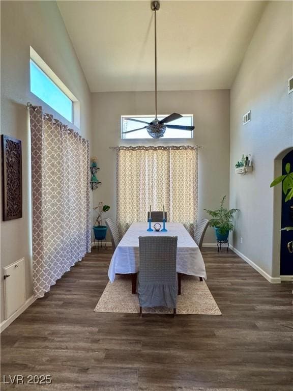 dining area with high vaulted ceiling, wood finished floors, and baseboards