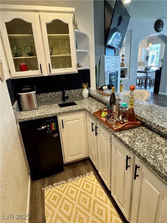 kitchen featuring dishwasher, dark wood-type flooring, white cabinets, and light stone counters