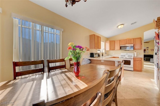 dining room featuring lofted ceiling and light tile patterned floors
