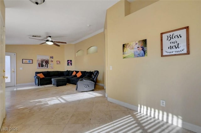 living area with baseboards, a ceiling fan, and light tile patterned flooring