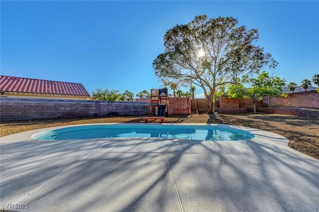 view of pool featuring a fenced backyard, a playground, and a patio