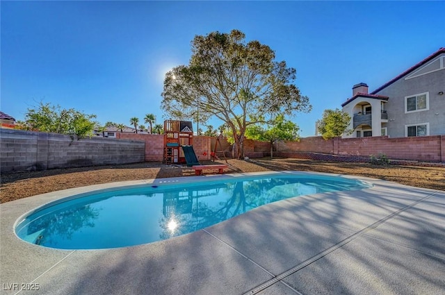 view of swimming pool featuring a playground, a fenced backyard, and a patio