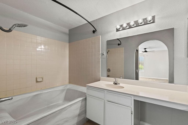 bathroom with a ceiling fan, bathing tub / shower combination, vanity, and a textured ceiling
