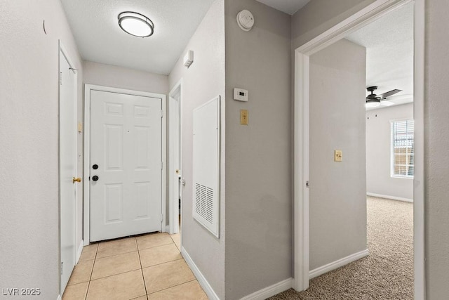 hallway featuring baseboards and light tile patterned floors