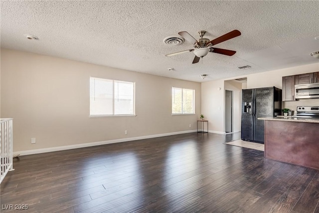 unfurnished living room featuring ceiling fan, a textured ceiling, dark wood finished floors, and baseboards