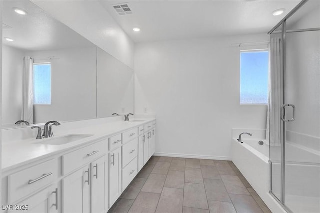full bathroom featuring recessed lighting, double vanity, a bath, a stall shower, and baseboards