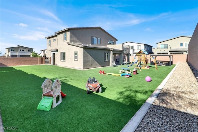 back of house featuring a playground and stucco siding