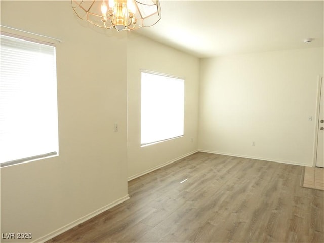 9470 Peace Way Unit 112, Las Vegas, NV 89147 - spare room featuring plenty of natural light, a chandelier, wood finished floors, and baseboards