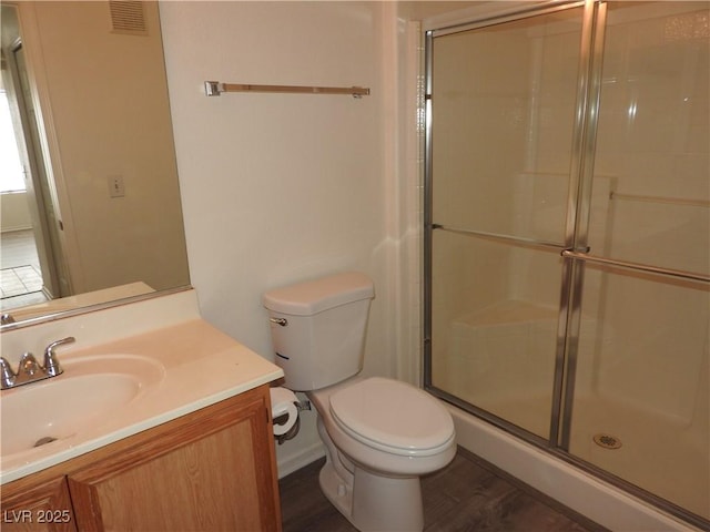 9470 Peace Way Unit 112, Las Vegas, NV 89147 - full bathroom featuring a shower stall, toilet, vanity, and wood finished floors