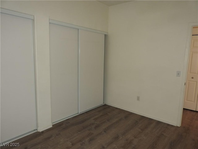 9470 Peace Way Unit 112, Las Vegas, NV 89147 - unfurnished bedroom featuring dark wood finished floors and baseboards