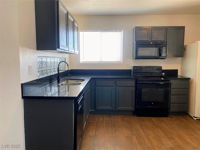 4910 Elizabeth St, Pahrump, NV 89048 - kitchen featuring black appliances, a sink, dark countertops, and wood finished floors