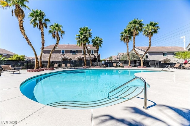 community pool featuring fence, a residential view, and a patio