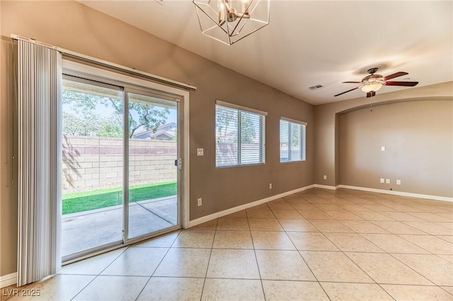 doorway with light tile patterned floors, baseboards, ceiling fan, and a chandelier