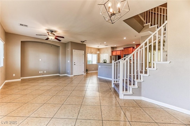 foyer featuring light tile patterned floors, stairway, baseboards, a ceiling fan, and a chandelier