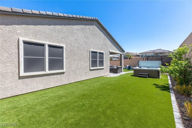 8929 Cassia Winds St, Las Vegas, NV 89166 - rear view of property featuring a hot tub, stucco siding, and a patio area