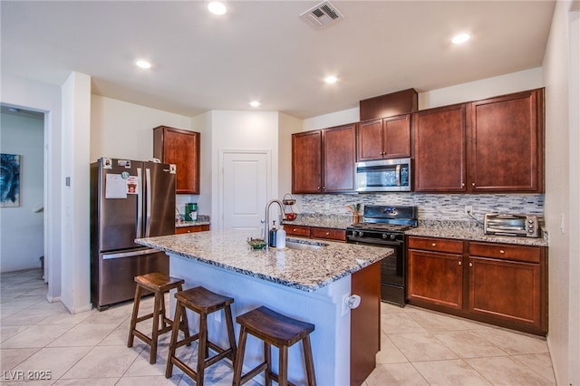 kitchen with appliances with stainless steel finishes, a sink, light tile patterned flooring, tasteful backsplash, and recessed lighting