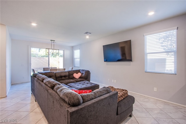 living area with light tile patterned flooring, recessed lighting, baseboards, and a chandelier