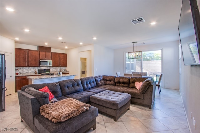 living room with a chandelier, light tile patterned floors, and recessed lighting