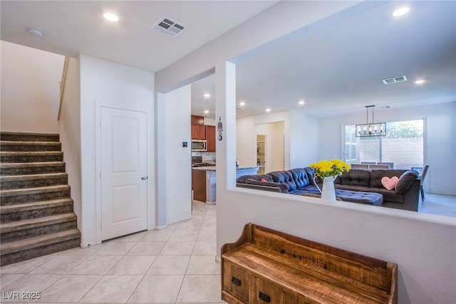 hallway with stairway, light tile patterned floors, a chandelier, and recessed lighting