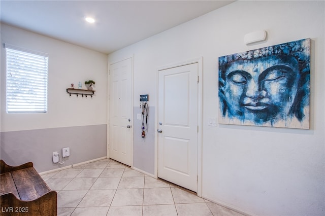 foyer entrance featuring light tile patterned flooring and baseboards