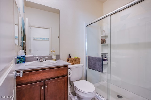bathroom featuring a stall shower, toilet, and vanity