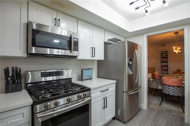9013 Cypress Point Way, Las Vegas, NV 89117 - kitchen featuring stainless steel appliances, light wood-type flooring, light countertops, and white cabinets