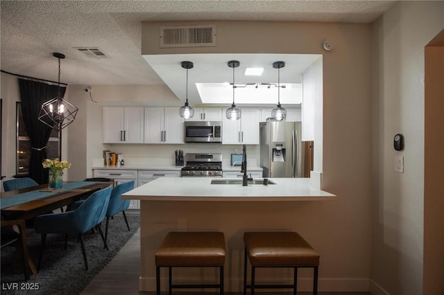 9013 Cypress Point Way, Las Vegas, NV 89117 - kitchen featuring stainless steel appliances, a sink, dark wood-type flooring, white cabinets, and a breakfast bar