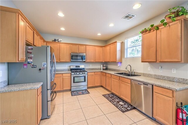 1213 High Altitude Ave, North Las Vegas, NV 89032 - kitchen with stainless steel appliances, a sink, light tile patterned floors, recessed lighting, and light brown cabinetry