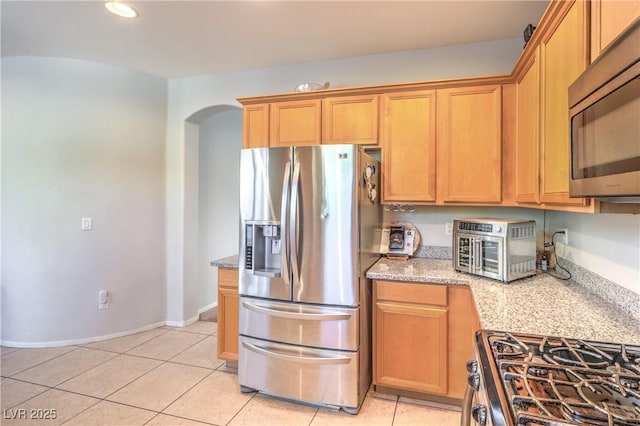 1213 High Altitude Ave, North Las Vegas, NV 89032 - kitchen with appliances with stainless steel finishes, arched walkways, light tile patterned flooring, light stone counters, and recessed lighting