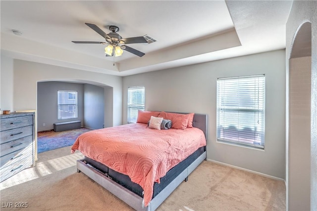 1213 High Altitude Ave, North Las Vegas, NV 89032 - bedroom with light colored carpet, a raised ceiling, arched walkways, baseboards, and a ceiling fan