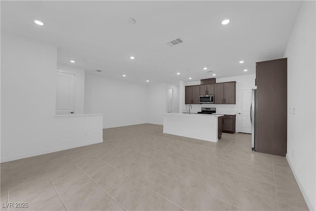 unfurnished living room featuring recessed lighting, a sink, and light tile patterned flooring