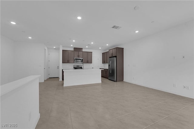 kitchen featuring appliances with stainless steel finishes, recessed lighting, dark brown cabinetry, open floor plan, and light countertops