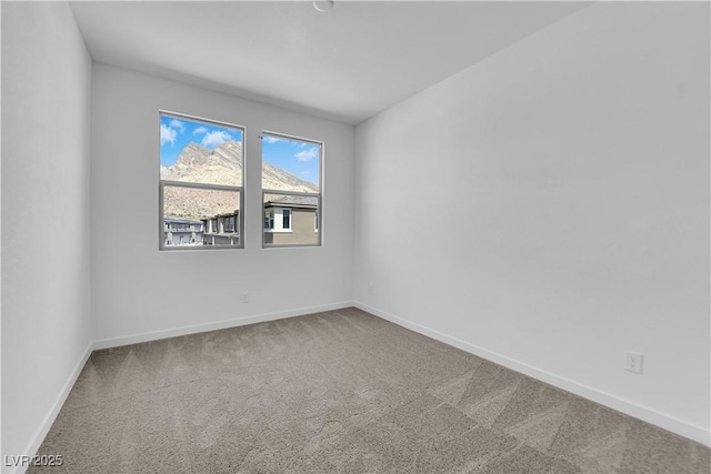 carpeted spare room featuring baseboards