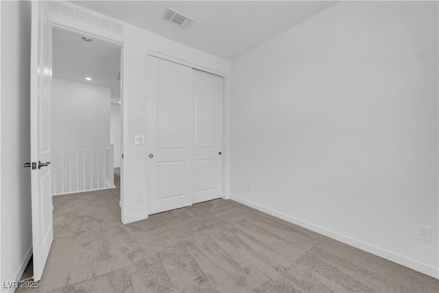 unfurnished bedroom with carpet, a closet, and baseboards