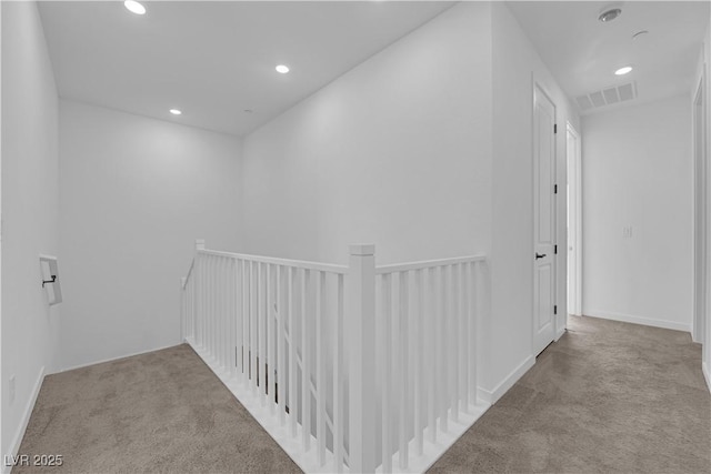 corridor featuring carpet flooring, an upstairs landing, and recessed lighting