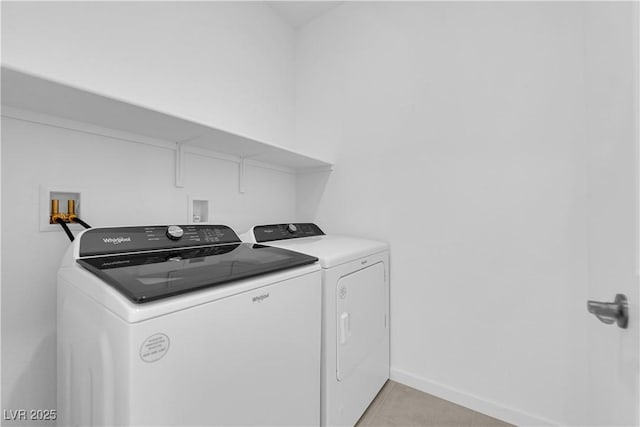 laundry room featuring washer and dryer, light tile patterned floors, and baseboards
