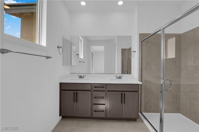 bathroom featuring a shower stall, double vanity, recessed lighting, tile patterned flooring, and baseboards