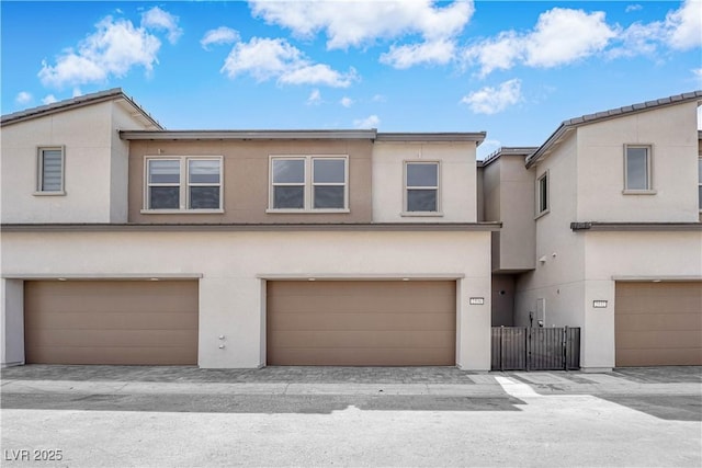 multi unit property featuring stucco siding, a garage, and fence